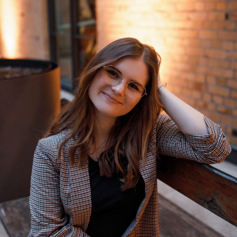 Portrait Annika Groß – Annlight Hypnose & Coaching Köln Annika Groß – Hypnose Coach aus Köln – sitzt entspannt auf einer Holzbank und lächelt. Persönliches Portrait für Annlight Hypnose &Coaching